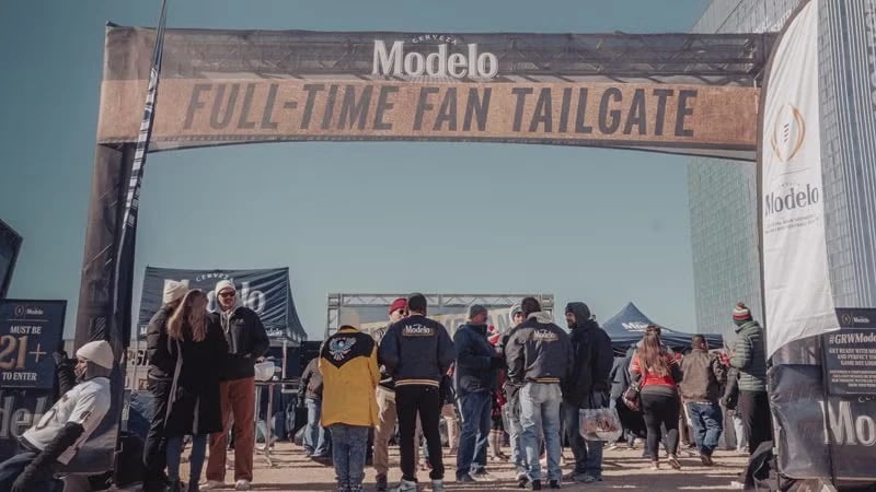 Fans gathering under the Modelo Full-Time Fan Tailgate arch at a college football activation by Cogent World